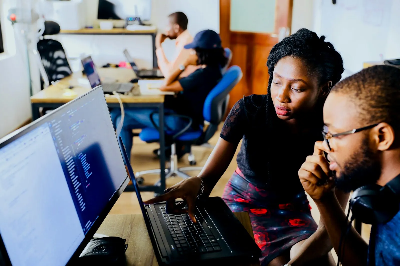 Two developers reviewing code together at a desk.