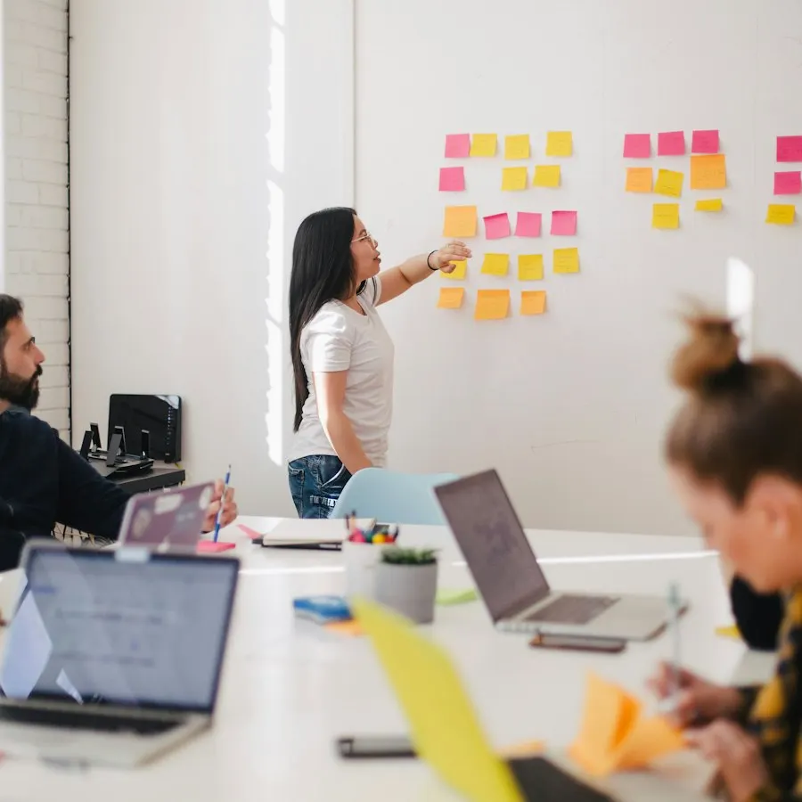 A product lead walking a team through a sticky-note plan at a workshop